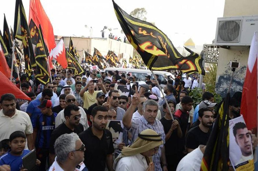Activist Nabeel Rajab (centre) flashes the V sign as he joins mourners marching during the funeral of killed protester Abdul-Aziz al-Abbar in Sanabis, 6 July 2014 / Photo Corbis