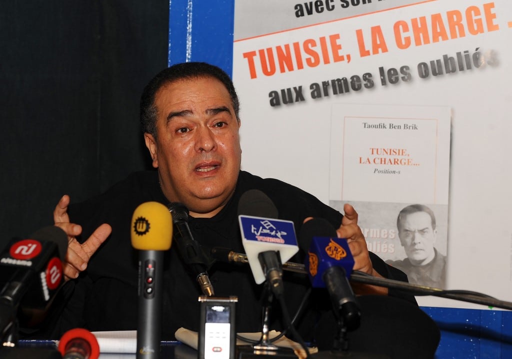 Tunisian journalist Taoufik Ben Brik gestures as he speaks carrot and stick