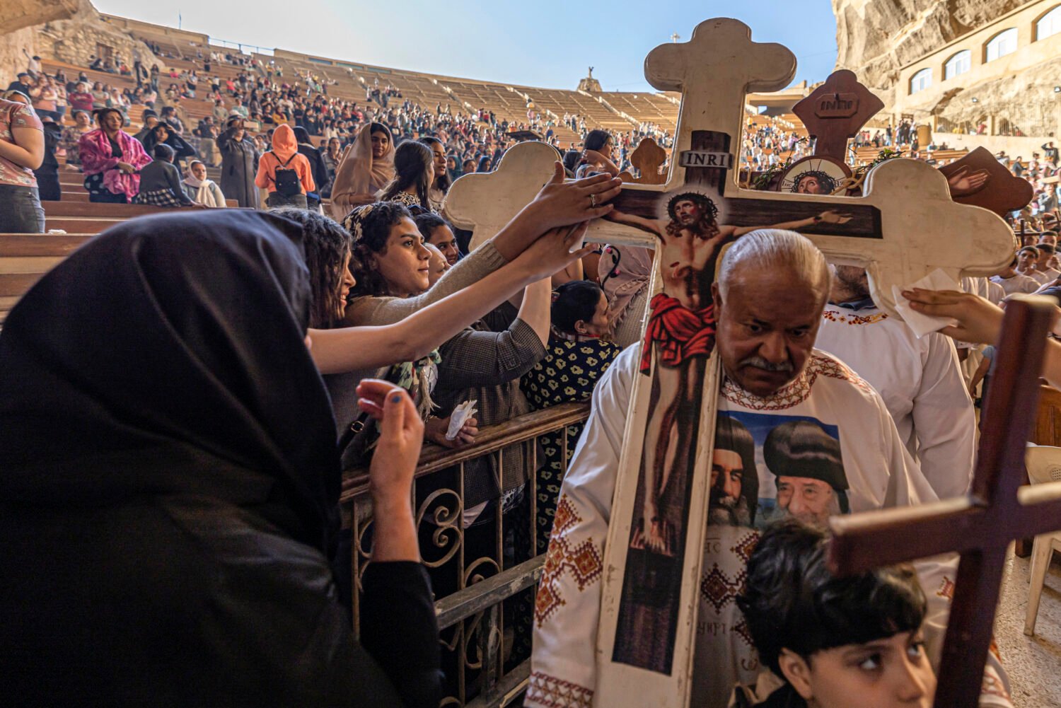 Coptic Orthodox Christians reach out to touch the cross