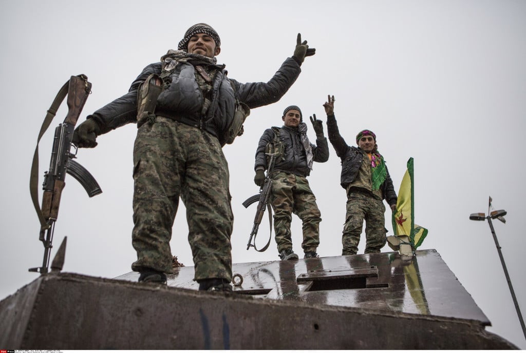 Kurdish YPG fighters stand on an armored truck confiscated from the Islamic State in Kobane, Syria, 30 January 2015. Photo 